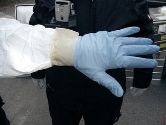 Der Handschuh wird am Schutzanzug festgeklebt (Bild anzeigen)